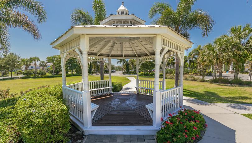 White gazebo with gorgeous landscaping and walking trails. 