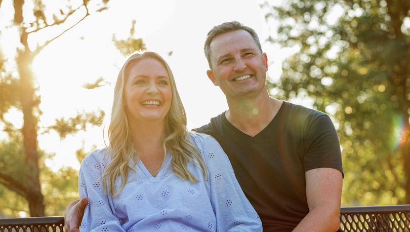 Couple sitting together with sunlight in the background.