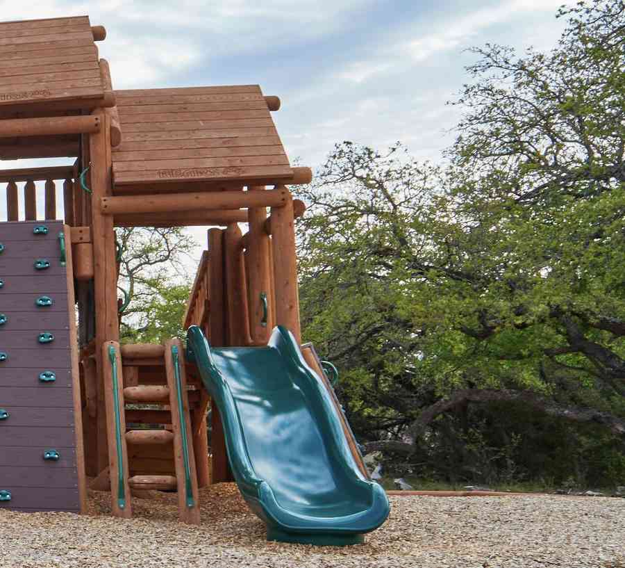 Rustic childrens playground with slides and climbing wall.