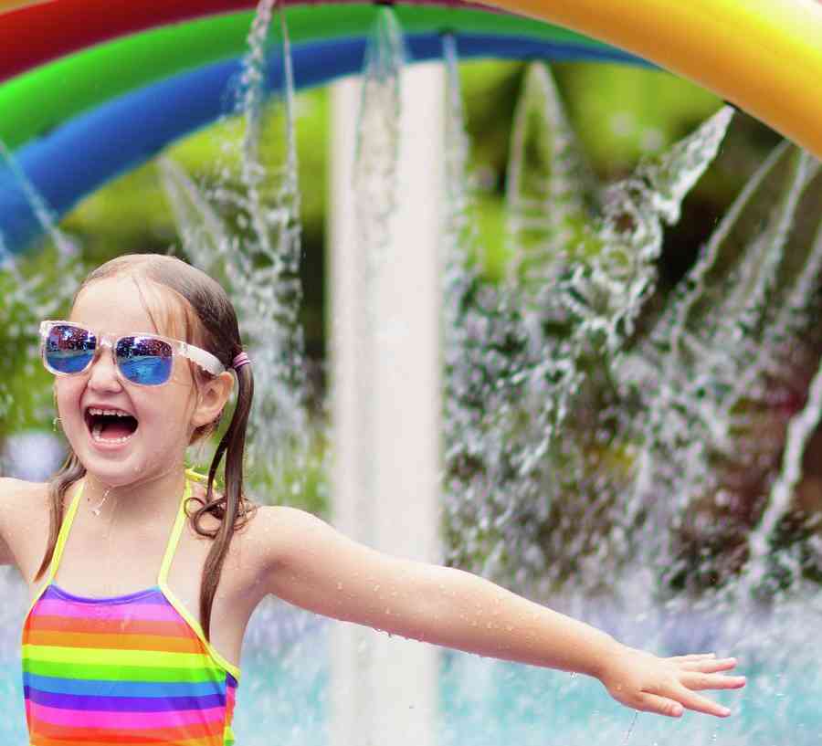 Girl playing on a colorful splash pad.