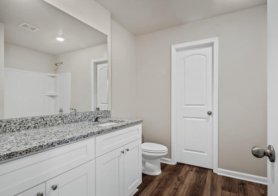 The bathroom has a tub/shower combo and a large vanity.