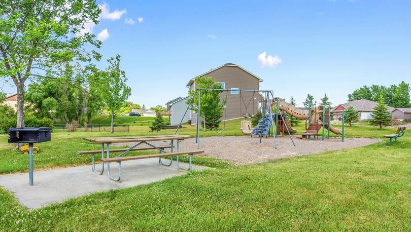 Park at Lake Ridge with a picnic table, swing set and playground.