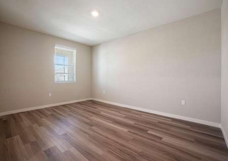 The Penny has a spacious flex room at the front of the home with wood style flooring and tan walls.