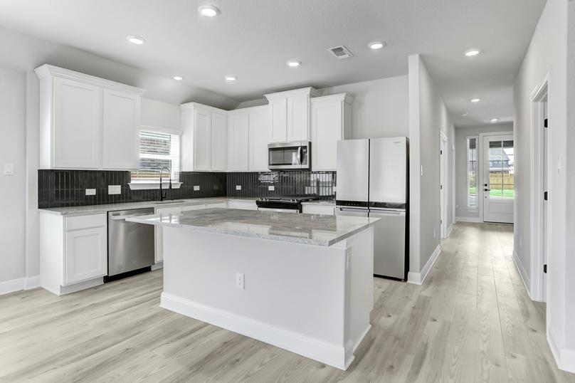 Gorgeous upgraded kitchen with granite countertops, stainless appliances, and wood-style flooring. 