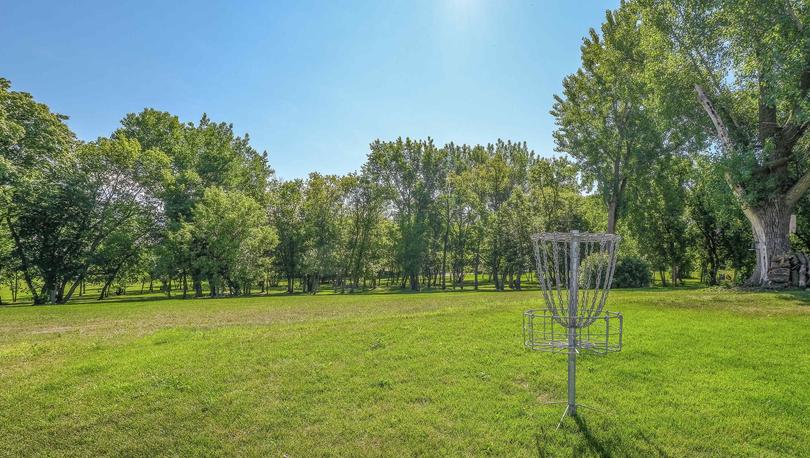 White Trail Ridge new home community park with frisbee golf, green grass, and large shade trees