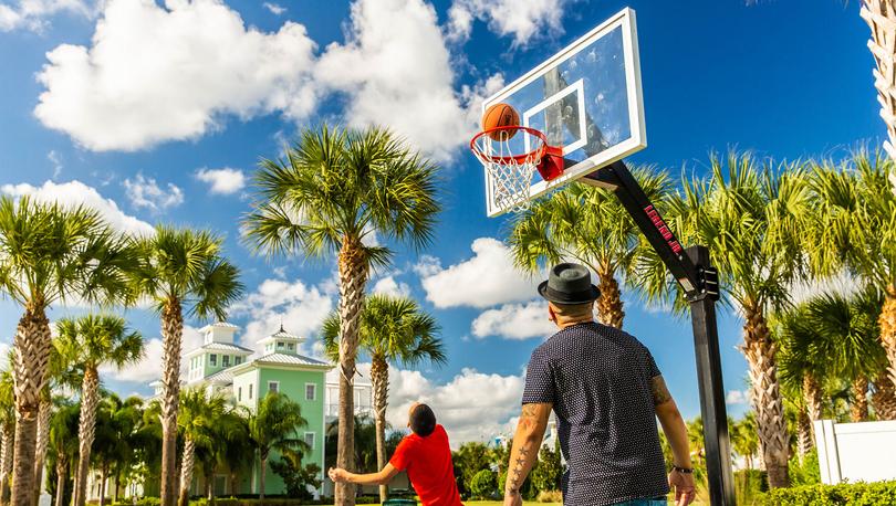 Two gentlemen playing outdoor basketball on a gorgeous day. 