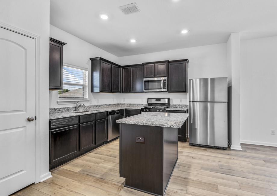 Upgraded kitchen with an island and granite countertops.