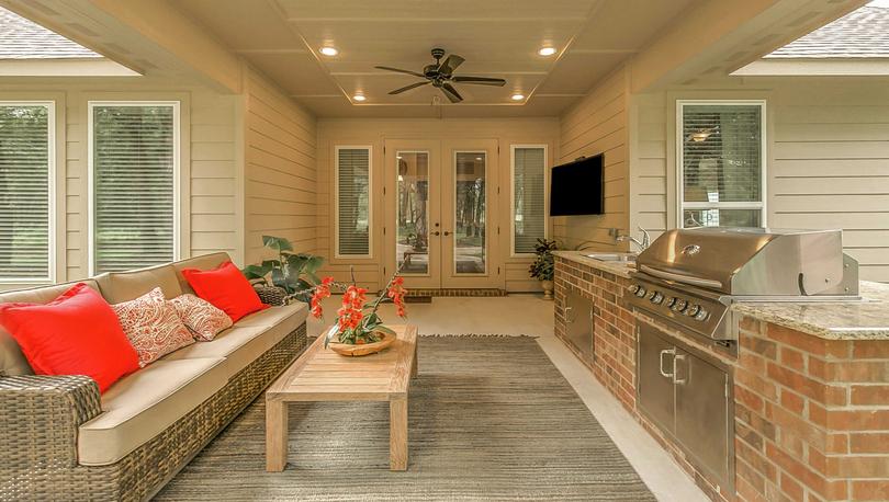 Staged covered outdoor kitchen with grill.