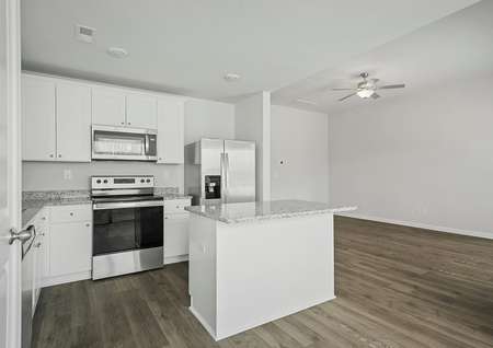 The kitchen has a stainless steel appliances and plank flooring.