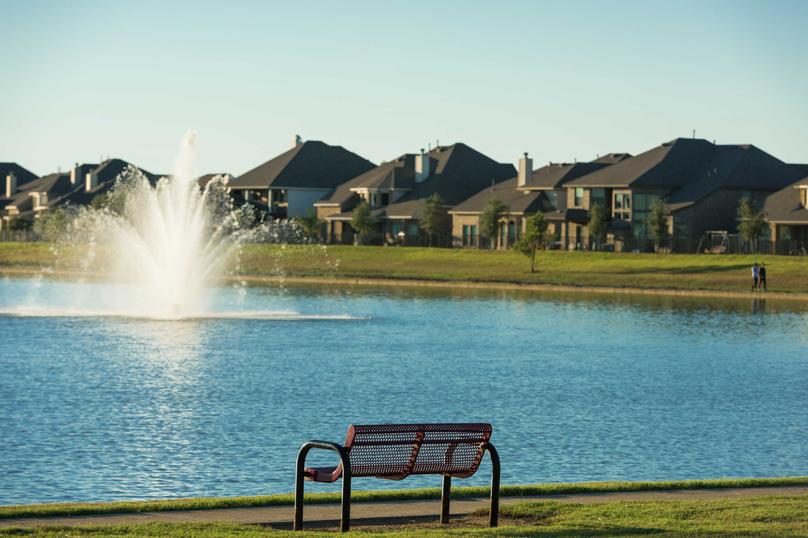 Bench in front of a lake with a fountain in the Sterling Lakes community
