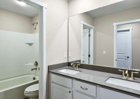 Secondary bathroom with dual sink vanity and tub/shower combo