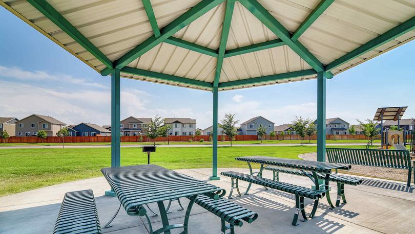 Metal covered pavilion with benches and tables in the Hidden Valley Farms park.