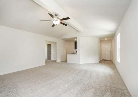Pecos great room with carpeted floors wall-to-wall, overhead ceiling fan, and white on white wall paint