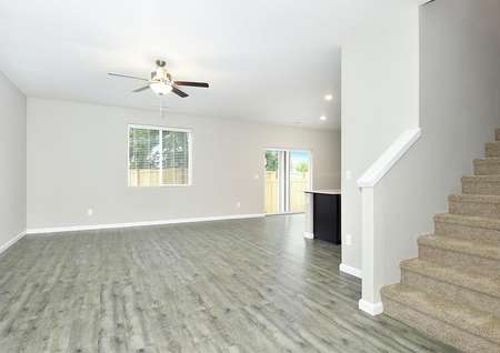 Spacious family room with a ceiling fan and plank flooring