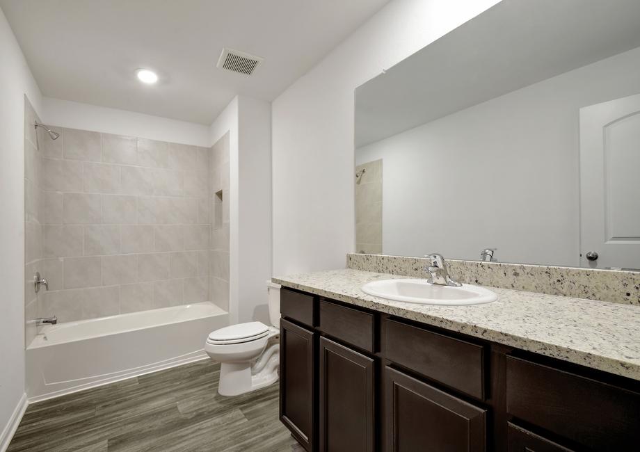 Secondary bathroom with granite countertops and a dual shower and bathtub. 