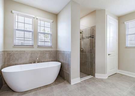 Master bathroom with tile floors, a walk-in shower and a standalone tub.