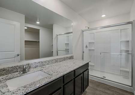 Incredible master bathroom with granite countertops and a walk-in shower.