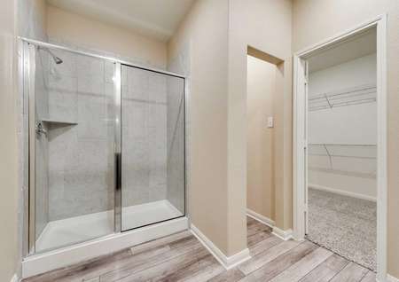 Erie master bath with tile shower, walk-in closet, and tiled floors
