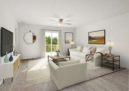 Photo of a transitional style living room with carpet, a ceiling fan, sliding glass door to a deck furnished with a white sofa, chair, tables, media cabinet and wall-mounted TV.