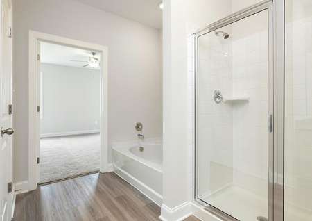 Primary bathroom with soaker tub and oversized glass enclosed shower.