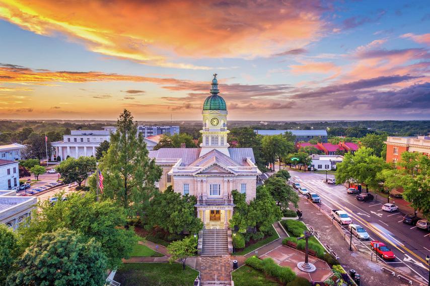 Athens, Georgia downtown area showing City Hall with it's copper cupola, downtown streets, and the sun setting over the horizon