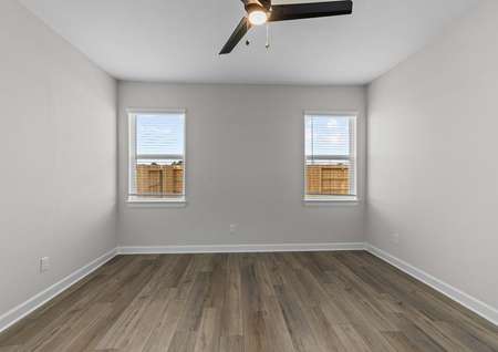 Master bedroom with plank flooring and a ceiling fan