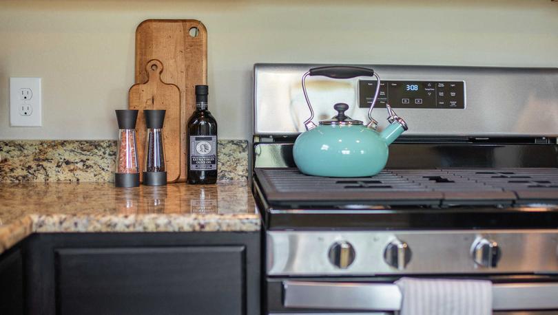 Kitchen staged with turquoise teapot, salt and pepper shaker, and cookie jar on countertop