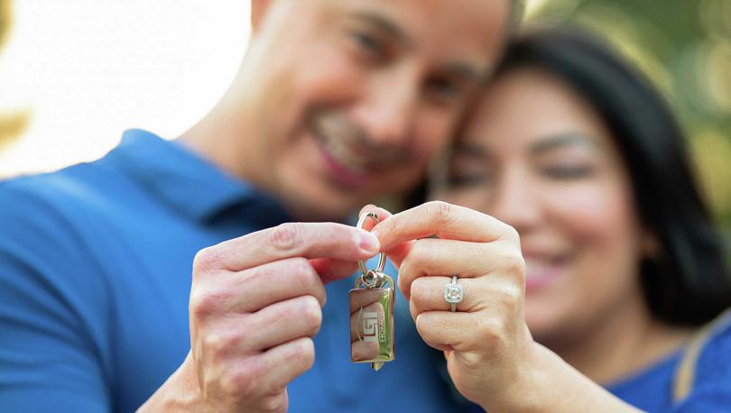 Happy customers holding the keys to their new LGI home.