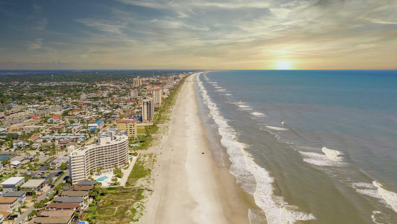 Jacksonville, Florida beach during pandemic lockdown with no beachgoers, condos and apartments, and rolling waves