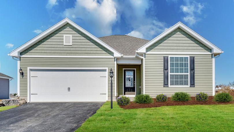 Martin exterior with pale green paint white trim black shutters and glass front door and green grass on hill
