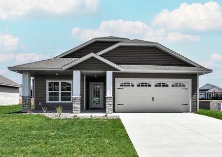 Front exterior photo of the one-story St Timothy home by LGI Homes in taupe siding with white trim and stone accents on the covered front porch.