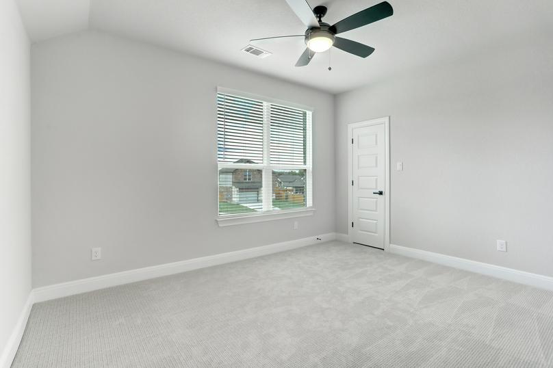 Guest bedroom with a ceiling fan, walk-in closet, and light gray carpet.
