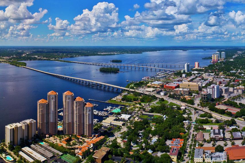 Fort Myers, Florida Caloosahatchee River with two bridges, tall buildings, and greenery in the distance
