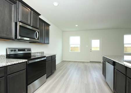 The spacious kitchen of the Mesquite by LGI Homes comes chef-ready with a full suite of stainless steel appliances and abundant high-grade wood cabinets.