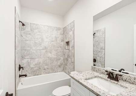 Secondary bathroom with a stunning tiled-lined shower and bathtub. 