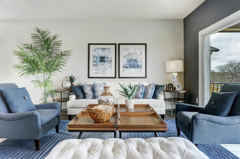 Staged living room with a white couch and blue chairs.