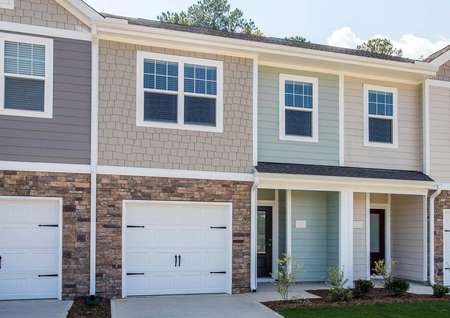 The two-story Bradford B exterior with an attached garage and stone accent detailing.