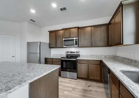 Beautiful brown cabinets and stainless steel appliances fill the heart of the home.