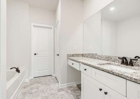 Master bathroom with granite countertops, a soaking tub, and walk-in shower.
