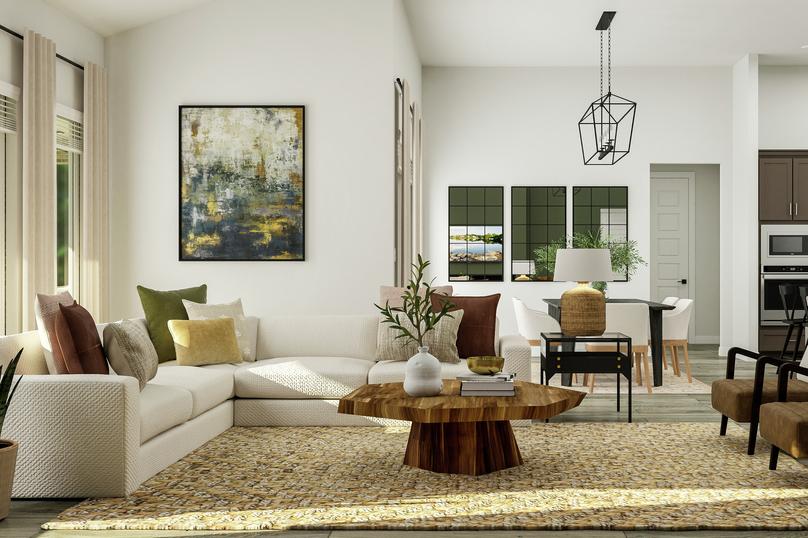 Rendering of the spacious family room
  featuring a large white sectional and accent chairs atop a natural rug. The
  kitchen and dining area are in the background.