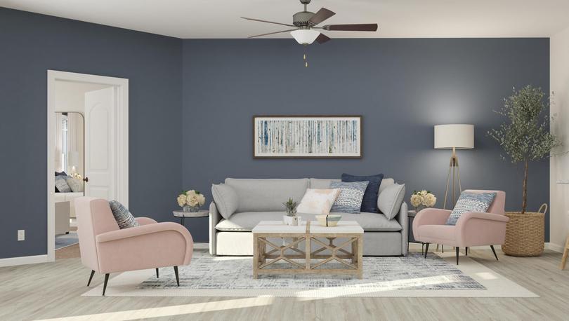 Rendering of the spacious living room in
  the Anna, which has wood-style flooring, a gray couch, two accent chairs and
  a coffee table. The master bedroom is visible through a doorway.
