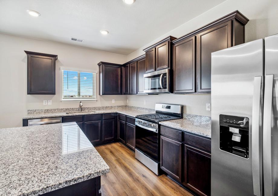 The kitchen features stainless steel appliances, granite countertops, and espresso cabinets.