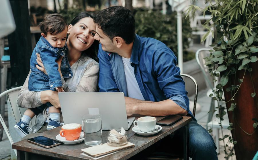 Mother, father and their baby boy spending time together outside of a café. 