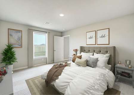 Staged bedroom with a gray bed with white linens.