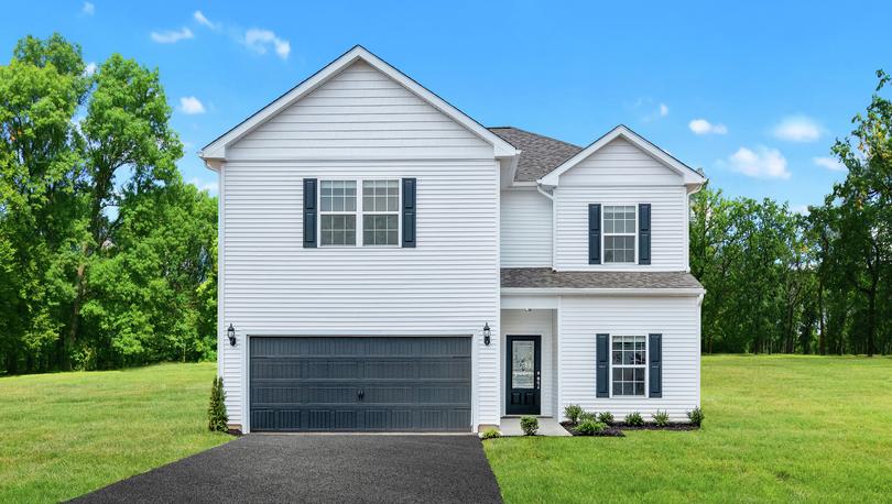 Front elevation photo of the 5-bedroom Potomac plan by LGI Homes, white siding with black shutters and black front door and asphalt driveway on oversized lot with trees at property line.
