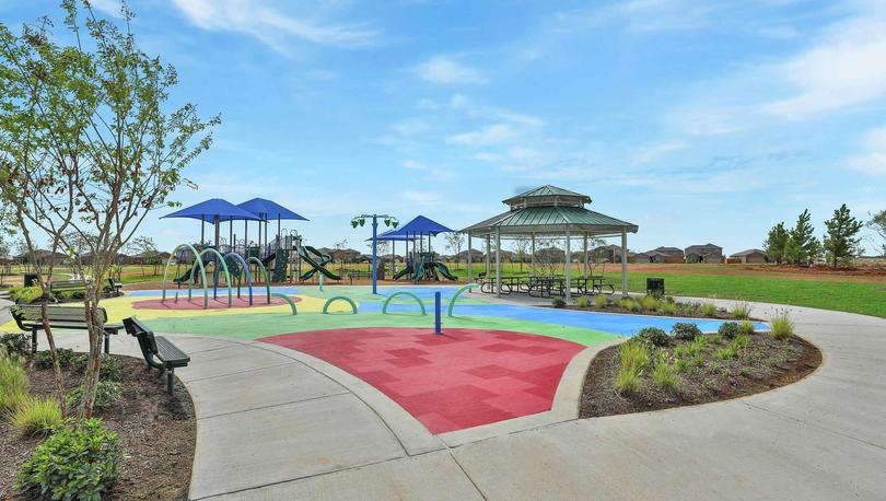 Children's playground and covered pavilion with benches alongside the walking path in the Freeman Ranch community