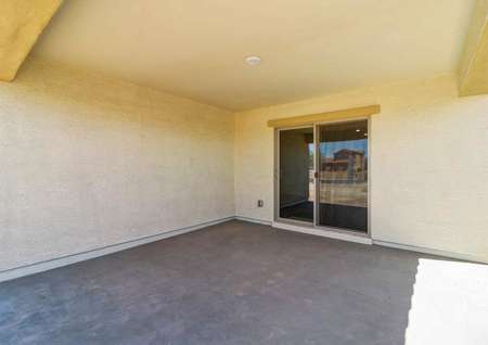 The covered back patio in the Guadalupe floor plan that has a sliding glass door and a light on the ceiling.