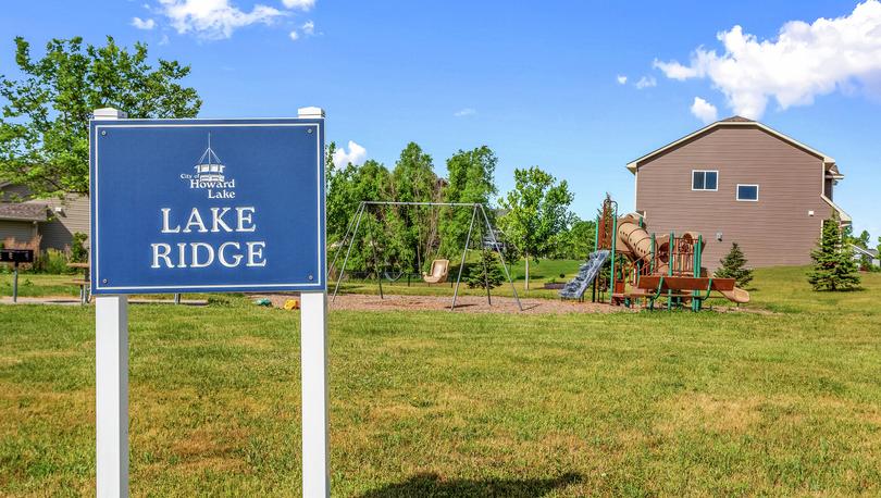 Lake Ridge sign with swing set and playground.