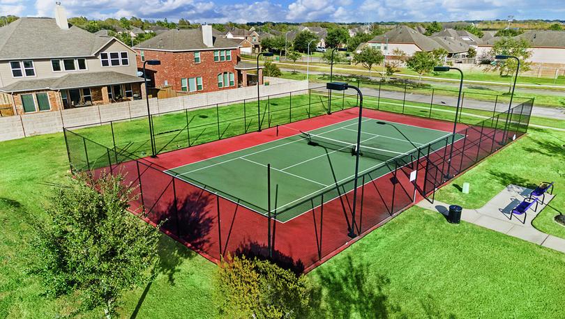 Tennis court surrounded by fence.