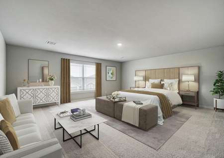 Staged master bedroom with a white sofa and tan bed linens.
